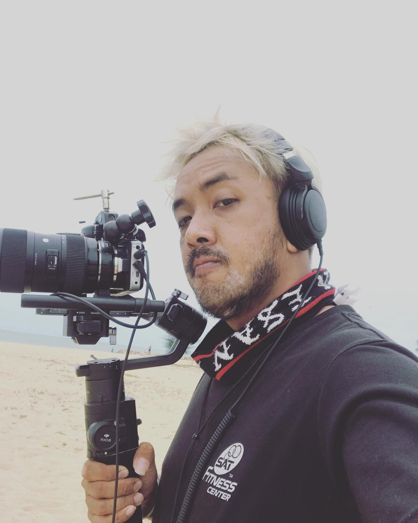 สิริชัยถือกล้องระหว่างทำงานถ่ายภาพ